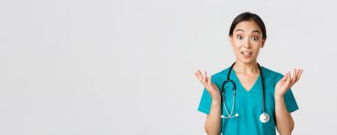 Sağlık çalışanları, virüsü önleme, karantina kampanyası konsepti. Şaşırmış ve eğlenmiş, mutlu Asyalı kadın hemşire, doktor harika haberler duyup, ellerini kaldırıp kameraya bak.