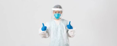 Covid-19, koronavirüs hastalığı, sağlık çalışanları konsepti. Ciddi görünümlü Asyalı kadın doktor, bulaşıcı bölgelerde kişisel koruma ekipmanlarıyla çalışıyor.
