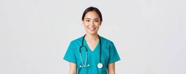 Sağlık çalışanları, virüsü önleme, karantina kampanyası konsepti. Gülümseyen hoş Asyalı kadın hemşire, önlüklü doktor neşeli görünüyor, hasta dinliyor, beyaz bir geçmişi var.