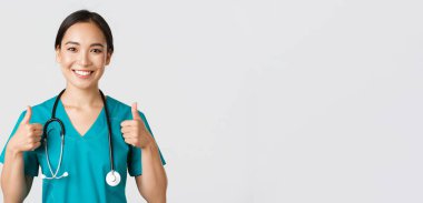 Sağlık çalışanları, virüsü önleme, karantina kampanyası konsepti. Neşeli gülümseyen Asyalı doktor, kendine güvenen doktor, hastayı sağlama al, onayını ver.