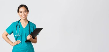 Sağlık çalışanları, virüsü önleme, karantina kampanyası konsepti. Gülümseyen hoş Asyalı kadın doktor, muayene sırasında doktor önlük giyiyor ve elinde dosya, beyaz arka plan.