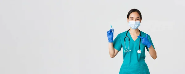 Covid-19, coronavirus disease, healthcare workers concept.有自信、友善的亚洲女医生、戴着医疗面罩的医生、用手指按注射器和疫苗擦拭的医生 — 图库照片