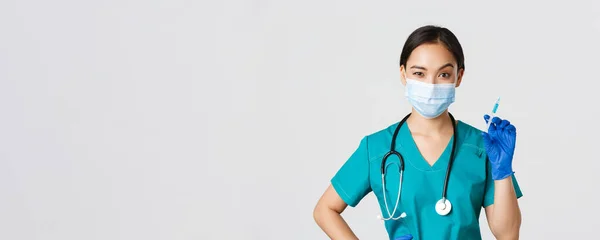 Covid-19, coronavirus disease, healthcare workers concept.性感可爱的亚洲女护士，戴着医疗面罩，头戴手套，拿着注射器，带着疫苗，随时准备拍摄，白色背景 — 图库照片