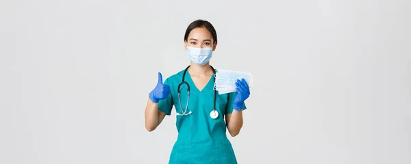 Covid-19, coronavirus disease, healthcare workers concept.微笑的亚洲医生，戴着刷子和橡胶手套的护士，露出大拇指和医疗面具，白色背景 — 图库照片