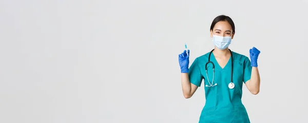 Covid-19, coronavirus disease, healthcare workers concept.亚洲女医生，戴着医疗面罩和手套的医生，高兴的胜利，拿着注射器和疫苗的喜悦的胜利 — 图库照片