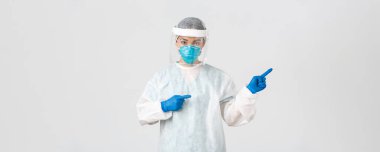Covid-19, koronavirüs hastalığı, sağlık çalışanları konsepti. Profesyonel kadın doktor, teknoloji laboratuarı çalışanı kişisel koruma ekipmanlarında parmak gösteren, yol gösteren, beyaz arka plan