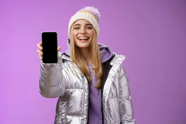Frech erfreut fröhliche blonde Frau empfehlen Verwendung App bearbeiten perfekte Bilder halten Smartphone zeigt Handy-Display stolz zufriedenstellend Lächeln Kamera, stehend lila Hintergrund — Stockfoto