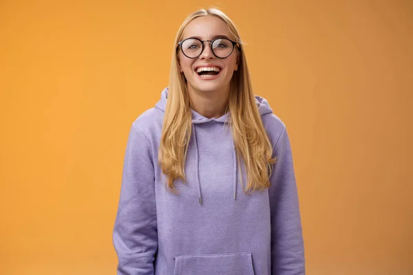 Charismatic alegre encantador sorrindo universidade feminina em linha reta um estudante em óculos roxo acolhedor capuz sorrindo rindo feliz feliz convidado mão para fora colegas de classe em pé fundo laranja — Fotografia de Stock