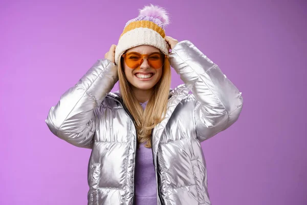 Energizado ousado atrevida jovem atraente mulher se divertindo amigos viagem de inverno aprender snowboard sorrindo atrevido desfrutar de férias colocar-on chapéu vestindo prata quente jaqueta óculos de sol, fundo roxo — Fotografia de Stock