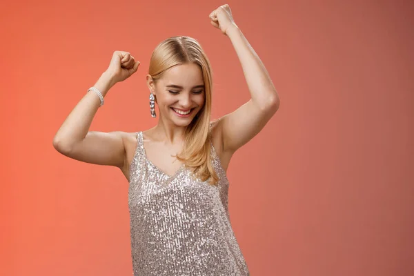 Joyful blond excited birthday girl having fun carefree dancing raised hands close eyes smiling enjoying night-out girlfriend nightclub have fun standing amused red background entertained — Stock Photo, Image