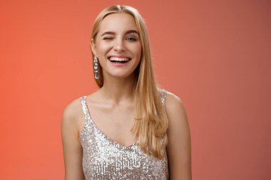 Kaygısız, neşeli, çekici, sarışın kadın partisi tüm gece boyunca gülümseyip eğlenin. Harika bir gece kulübünün tadını çıkarın. Gümüş renkli, şık bir elbise içinde dans edin.