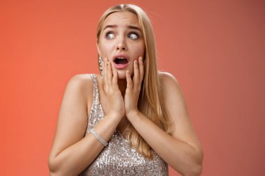 Korkmuş kız paniği korkmuş, korkudan titreyen, güvensiz, yanaklara dokunan, yan yan bakan, soluk soluğa kalmış korkmuş, gergin bir şekilde bekleyen yardım bekleyen, endişeli kırmızı arka plan.