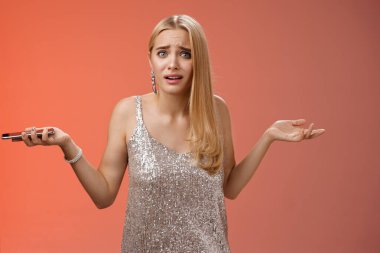 Hüsrana uğramış, terk edilmiş, sarışın, çekici kız arkadaşı omuz silkiyor. Sorgulanmış gibi görünebilir. Sorgulanmış, bilgisiz.