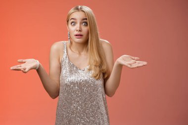 Emin olamayan, tuhaf, çekici, gümüş renkli, çekici Avrupalı kadın ellerini silkeliyor. Geniş bakışlar, kaşlarını kaldırıyor. Ne olduğundan habersiz, kafası karışmış, sorgulanıyor.