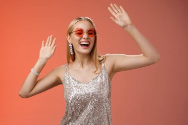 Neşeli, neşeli, sarışın kadın dans pistine çıkıp eğleniyor. Kapalı gözlerle bağırarak eğleniyor. El sallıyor, ritim tutuyor.