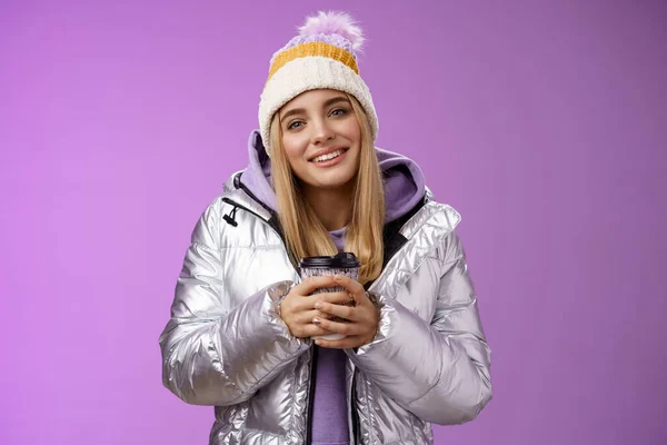 Tender relaxed cheerful smiling blond girl look pleased relieved drinking hot coffee cacao enjoying nice heartwarming moment look camera delighted gentle grin, wearing winter jacket hat — Stock Photo, Image