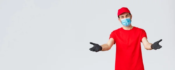 Covid-19, self-quarantine, online shopping and shipping concept. Friendly delivery man in face mask and gloves, reaching hands to receive package from client, provide delivering during coronavirus — Stock Photo, Image