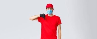Erzak ve paket teslimatı, covid-19, karantina ve alışveriş konsepti. Hayal kırıklığına uğramış ve isteksiz teslimatçı adam diğer servislerden hoşlanmıyor. Yüz maskesi ve eldiven kullanmıyor.