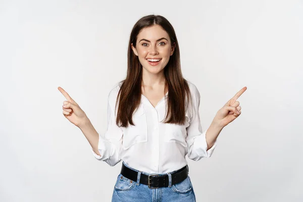 Mujer adulta sonriente feliz señalando hacia los lados, mostrando dos opciones, productos en venta logotipo o diagrama, de pie sobre fondo blanco — Foto de Stock