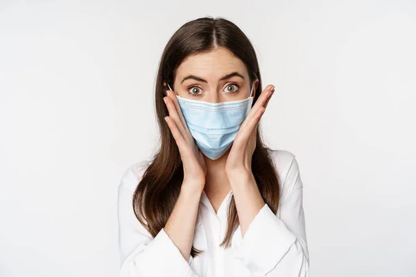 Covid-19 and pandemic concept. Young office woman wearing medical mask during coronavirus social distancing, standing over white background — Fotografia de Stock