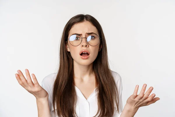 Close up of confused brunette woman in glasses, looking puzzled and clueless, standing over white background — Stock Photo, Image