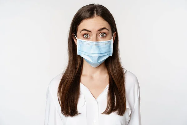 Covid-19とパンデミックの概念。コロナウイルスの社会的距離の間に医療マスクを身に着けている若いオフィスの女性は、白い背景の上に立って — ストック写真