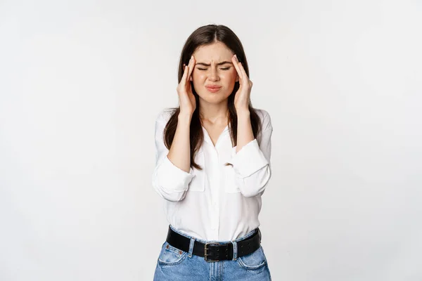 Vállalati nő grimaszoló, megható fej, érzés fejfájás, súlyos migrén, álló fehér háttér — Stock Fotó