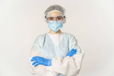 Professional doctor in personal protective equipment from coronavirus, cross arms on chest, looking confident, standing over white background