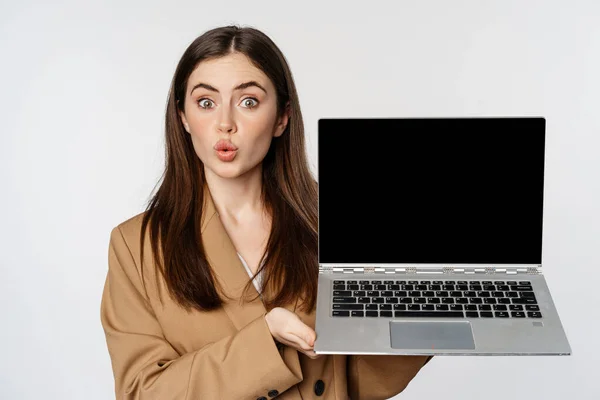 Χαμογελαστή επιχειρηματίας, πωλήτρια που δείχνει οθόνη laptop, επίδειξη της ιστοσελίδας, λογότυπο, στέκεται ενάντια στο λευκό φόντο — Φωτογραφία Αρχείου