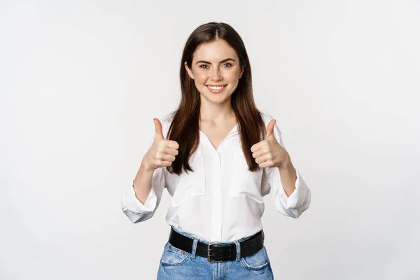Menina sorridente feliz mostrando polegares para cima, estudante com feedback satisfeito, recomendando smth, de pé sobre fundo branco — Fotografia de Stock