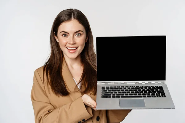 Усміхнена бізнес-леді, продавчиня, що показує екран ноутбука, демонструє веб-сайт, логотип, стоїть на білому тлі — стокове фото