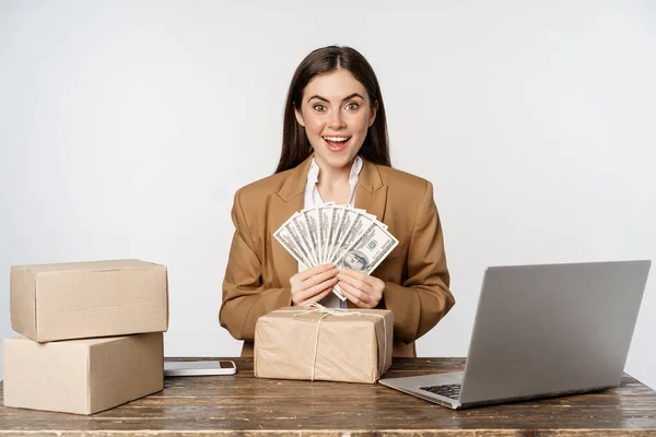 Portrait of businesswoman sitting in office with money, working and making profit income, posing happy against white studio background — Φωτογραφία Αρχείου