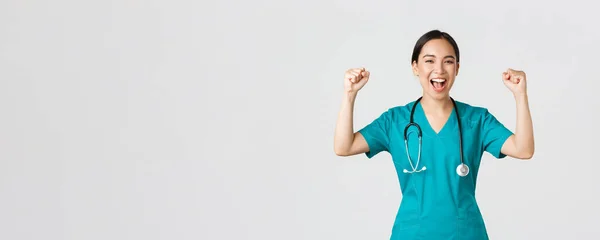 Covid-19, pracownicy służby zdrowia i zapobieganie koncepcji wirusa. Sukces pewny azjatycki lekarz lub pielęgniarka w peeling pięść pompy i krzycząc tak, radując się, zachęcić się, dążyć do zwycięstwa — Zdjęcie stockowe