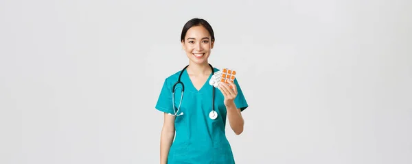 Sjukvårdspersonal, förebyggande av virus, karantänkampanjkoncept. Vänliga utseende kvinnliga asiatiska sjuksköterska, läkare förklara patient medicin recept, visar droger och leende, vit bakgrund — Stockfoto