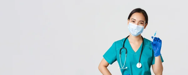 Covid-19, onemocnění koronavirem, koncept zdravotnických pracovníků. Usmívající se veselý asijský lékař, zdravotní sestra v lékařské masce a gumové rukavice připravit injekční stříkačku s vakcínou pro injekci vakcinace, bílé pozadí — Stock fotografie