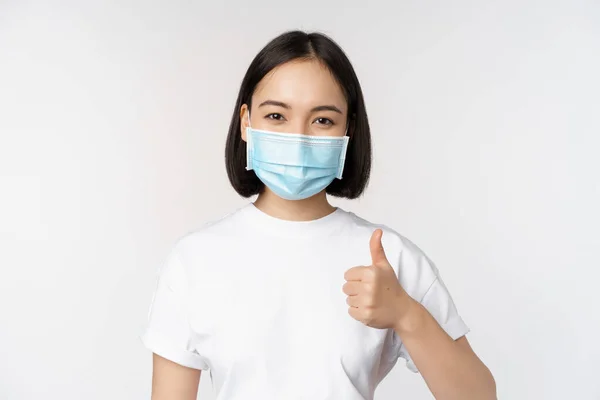 Sonriendo Chica Asiática Máscara Médica Mostrando Los Pulgares Hacia Arriba — Foto de Stock