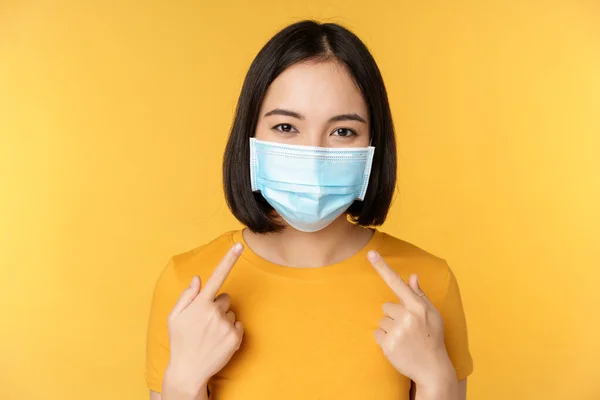 Porträtt Leende Asiatisk Kvinna Medicinsk Ansiktsmask Pekar Hennes Personliga Skyddsutrustning — Stockfoto