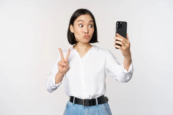 Lustiges Asiatisches Mädchen Zeigt Frieden Zeichen Smartphone Kamera Posiert Für — Stockfoto