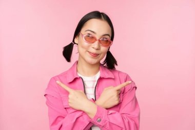 Tercih. Tarz sahibi Koreli bir kız, Asyalı bir kadın model, iki farklı modeli gösteriyor, ürün reklamları, ürünleri gösteren, pembe arka planda duran