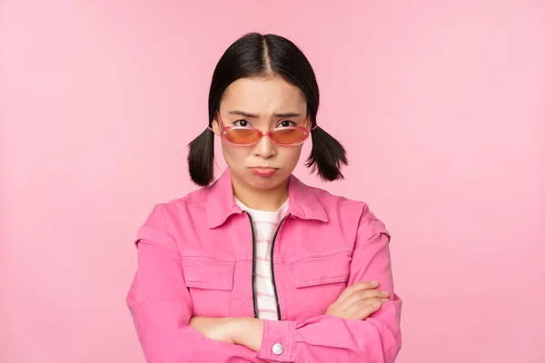 Ritratto di triste e cupa ragazza asiatica imbronciata dalla delusione, sconvolta contro lo sfondo rosa dello studio — Foto Stock