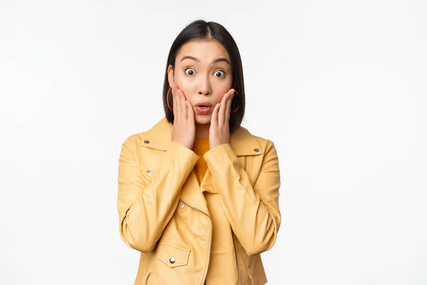 Image of asian woman looking surprised, amazed reaction, shocked face, standing over white background — Stock Photo, Image