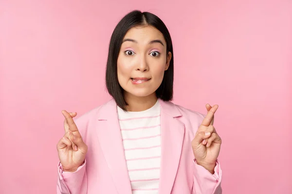 Feliz afortunada empresaria, asiática dama corporativa deseando, pidiendo deseo, esperando smth y orando, de pie en traje sobre fondo rosa —  Fotos de Stock