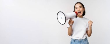 Asyalı kız megafona bağırıyor, genç aktivist protesto ediyor, yüksek sesle hoparlör kullanıyor, anons yapıyor, beyaz arka plan