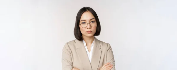 Profissional asiático empresária em óculos, olhando confiante para a câmera, de pé em poder posar contra fundo branco — Fotografia de Stock
