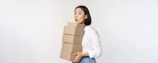 Retrato de mujer asiática joven sosteniendo cajas, llevar mercancías de entrega. Mujer emprendedora coreana montar orden, de pie voer fondo blanco —  Fotos de Stock