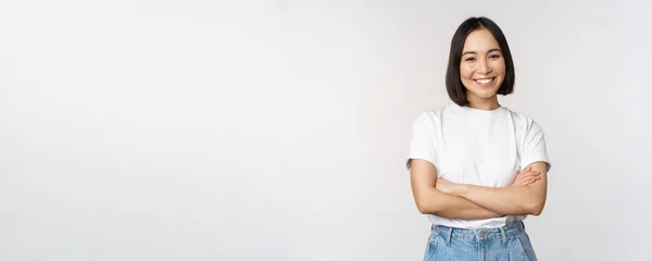 Portrait de femme asiatique heureuse souriante, posant confiante, bras croisés sur la poitrine, debout sur fond de studio — Photo