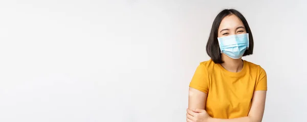 Friska och glada asiatiska kvinna i medicinsk ansiktsmask, har band stöd på axeln efter covid-19 vaccination, vaccinerades från omicron delta variant, whtie bakgrund — Stockfoto