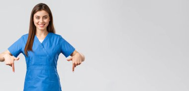 Sağlık çalışanları, virüsü önleyin, covid-19 test taraması, tıp konsepti. Mavi önlüklü, kendine güveni tam hemşire, doktor ya da stajyer hastalara bilgi verirken parmaklarını aşağıya doğru gösteriyor.