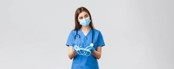 Covid-19, megelőzés vírus, egészségügyi dolgozók és karantén koncepció. Vonzó női ápolónő kék köpenyben és egyéni védőfelszerelésben, orvosi maszkot adva a betegnek — Stock Fotó