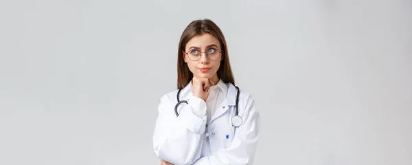 Operatori sanitari, medicina, assicurazione e covid-19 concetto di pandemia. Preoccupato incerto giovane medico donna prendere decisioni serie, sorridere guardare premuroso, sorridere dispiaciuto, pensando scelta difficile — Foto Stock